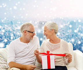 Image showing happy senior couple with gift box at home