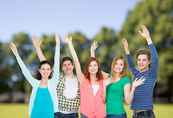 Image showing group of smiling students waving hands