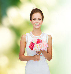 Image showing smiling woman in white dress with bouquet of roses