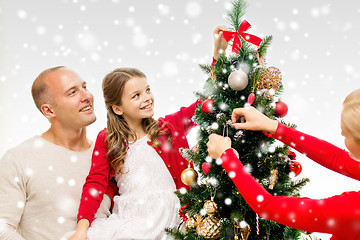 Image showing smiling family decorating christmas tree at home