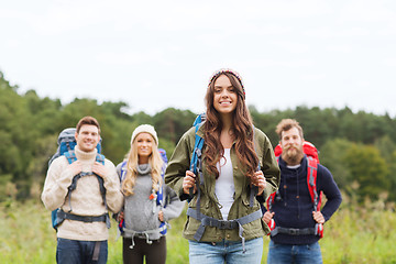 Image showing group of smiling friends with backpacks hiking