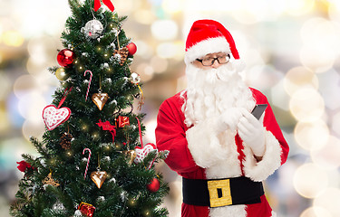 Image showing santa claus with smartphone and christmas tree