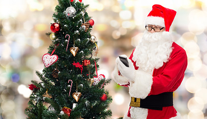 Image showing santa claus with smartphone and christmas tree