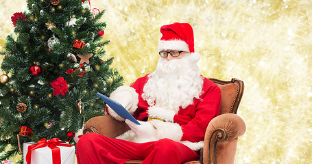 Image showing man in costume of santa claus with tablet pc