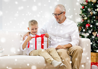 Image showing smiling grandfather and grandson with gift box