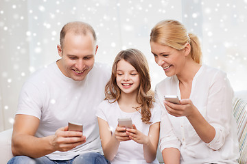 Image showing happy family with smartphones at home