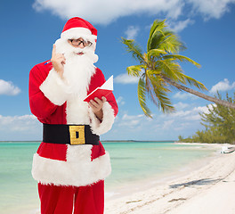 Image showing man in costume of santa claus with notepad