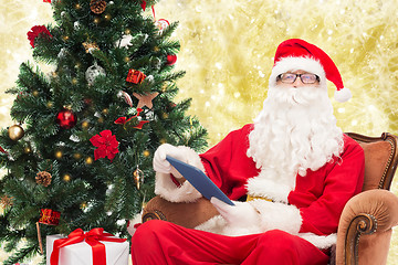 Image showing man in costume of santa claus with tablet pc