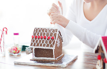 Image showing close up of woman making gingerbread house at home