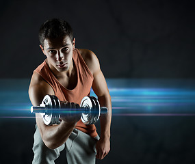 Image showing young man with dumbbell flexing biceps