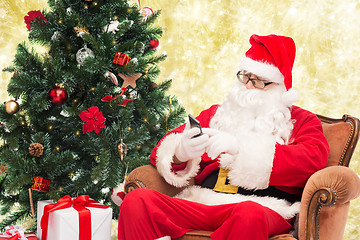 Image showing santa claus with smartphone and christmas tree