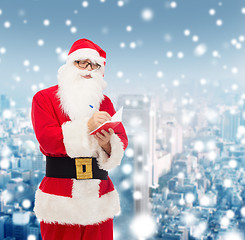 Image showing man in costume of santa claus with notepad