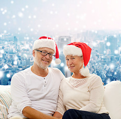 Image showing happy senior couple in santa helper hats