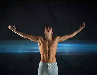 Image showing young male bodybuilder with raised hands