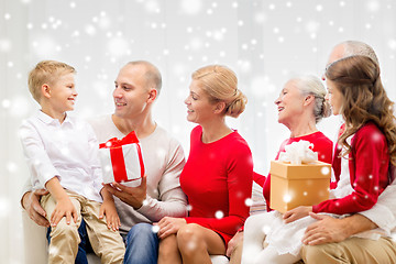 Image showing smiling family with gifts talking at home