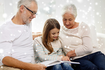 Image showing smiling family with book at home