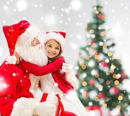 Image showing smiling girl with santa claus and gift at home