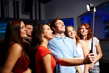 Image showing friends with smartphone taking selfie in club