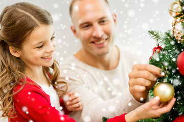 Image showing smiling family decorating christmas tree at home