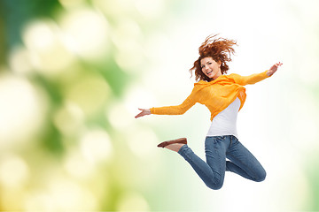 Image showing smiling young woman jumping high in air