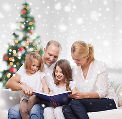 Image showing happy family with book at home