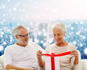 Image showing happy senior couple with gift box at home