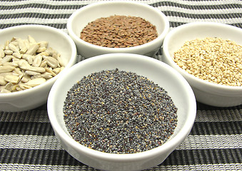 Image showing Four bowl with different seeds on a striped background