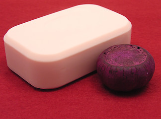 Image showing Pink soap with decoration articles on a  red background