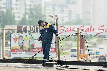 Image showing Worker holds a gas torch to waterproofing
