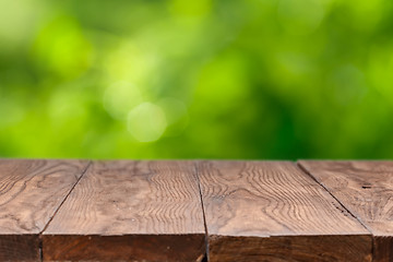 Image showing Empty wooden table against green background