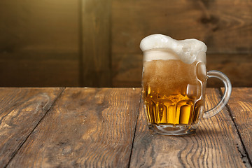 Image showing Light beer in mug on wood