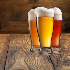 Image showing Different beer in glasses on wood