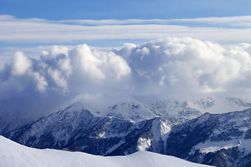 Image showing Snowy mountains in clouds and off-piste slope