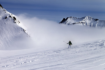 Image showing Snowboarder downhill on off-piste slope with newly-fallen snow