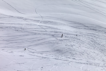 Image showing Silhouettes of snowboarders and skiers on off piste slope
