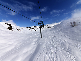 Image showing Chair-lift and off-piste slope in sun day