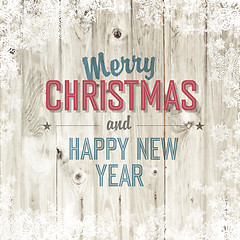 Image showing Merry Christmas greeting on blond wooden background