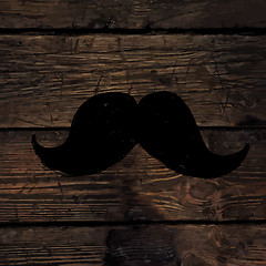 Image showing Moustache symbol on wooden texture.