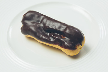 Image showing Single chocolate eclair on white  plate