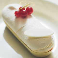 Image showing Single eclair with space for text on white plate.