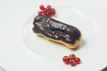 Image showing Single chocolate eclair on white  plate