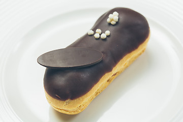 Image showing Single chocolate eclair on white  plate