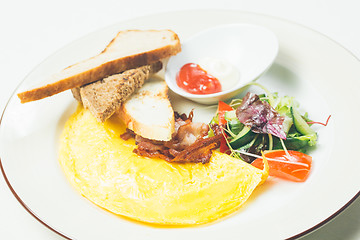 Image showing Omelet with bacon served on white plate, vegetables aside