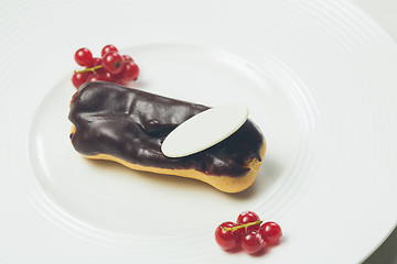 Image showing Single chocolate eclair on white  plate