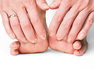 Image showing Hands pulling toes on barefoot feet with shadow effect