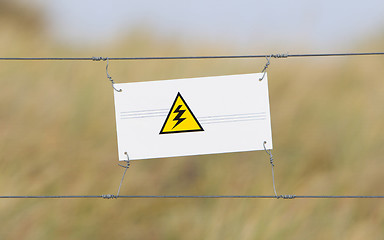 Image showing Border fence - Old plastic sign with a flag