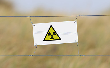 Image showing Border fence - Old plastic sign with a flag