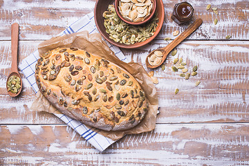 Image showing Newly fledged bread with pumpkin seeds on wooden table