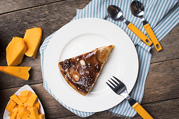 Image showing Breakfast pie on plate and pieces of pumpkin on wood