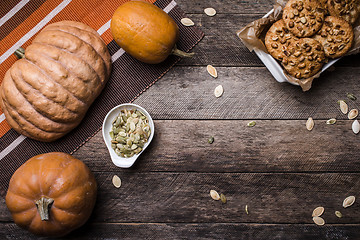 Image showing Pumpkins with seeds and  cookies on wood in Rustic style